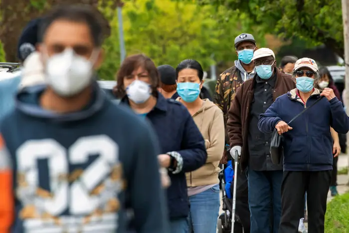 Residents of the Kew Gardens Hills neighborhood of the Queens borough of New York line up for free face masks May 5th, 2020.